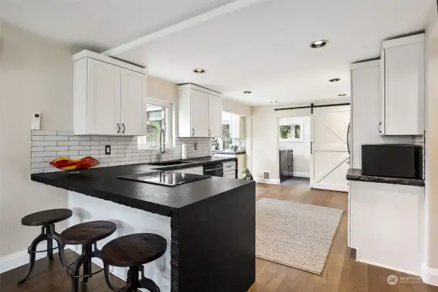 Oversized Kitchen w/so many amenities! White Cabinets w/Soft-Close Drawers & Doors. New Hardware & Crown Molding. Recessed Lighting. Black Granite Counters w/Waterfall sides, brick-style tile backsplash.