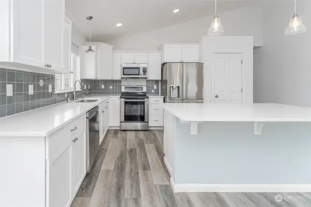 Clean, bright kitchen with eating bar and chic quartz countertops