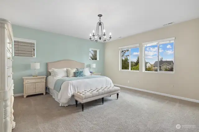 Sprawling primary bedroom upstairs feels grand and offers private views with tons of natural light.