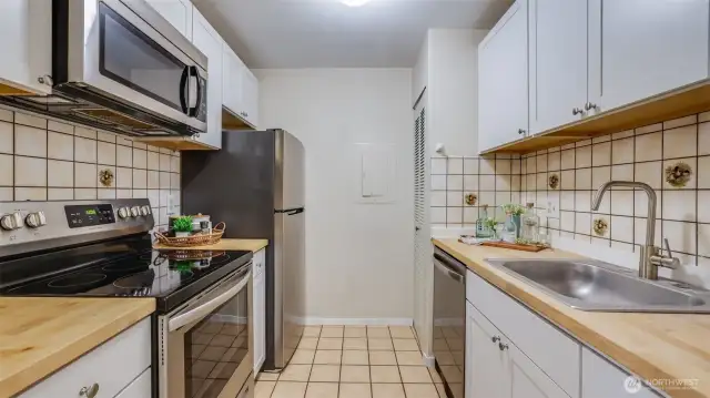 The kitchen boasts newer white cabinets, new butcher block countertops and all stainless steel appliances.