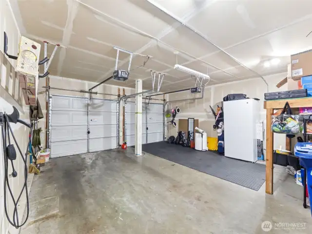 Spacious 2-car garage w/openers & some shelving for added storage. Plus 240 volt plug-in for EV.