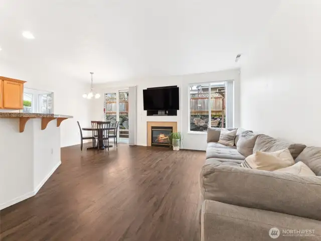 Great Room featuring wood laminate floor, high ceilings, & gas fireplace.