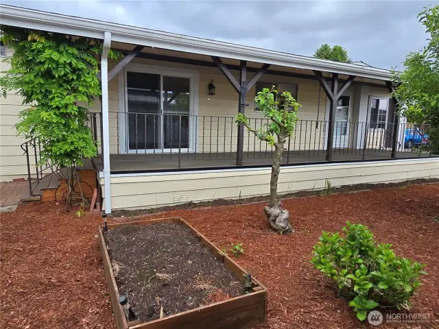 Front entry of home with raised gardening beds, Strawberries planted. Newer non slip porch with pull down privacy screens