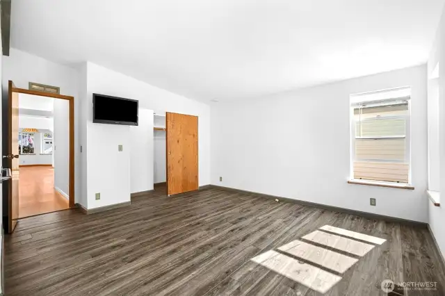 Expansive primary bedroom with natural light, large closet, and ensuite bath. Windows overlook the peaceful, private backyard.