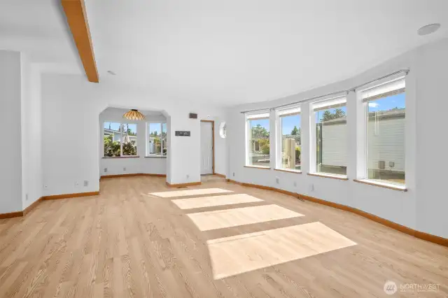 Bright, open living space with vaulted ceilings. View toward entry and breakfast nook.