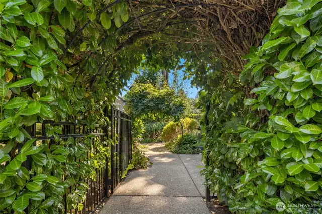 This beautiful, gated laurel archway leads to the front entry and patio sitting area.
