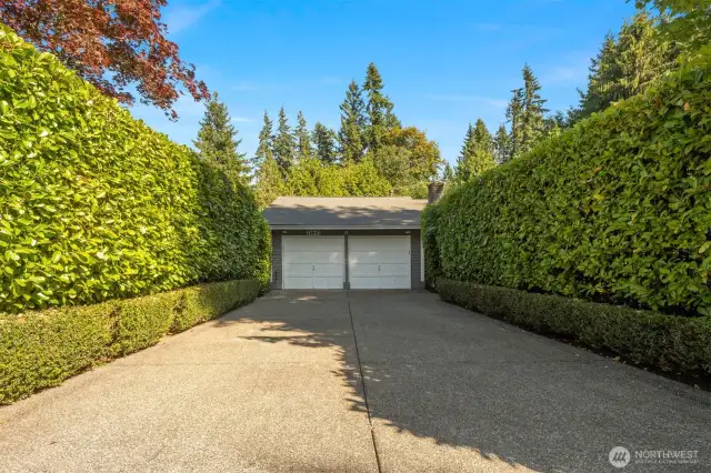 Driveway access to the two car garage with EV charger. Gated entries / archways are located on each side of the driveway near the garage.