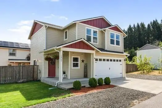 Front view of home has great curb appeal, angled entry door, covered entry area for small patio furniture and two graveled areas for parking or RV/boat storage.