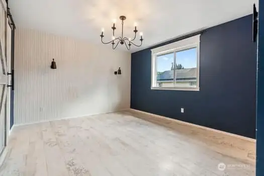 Primary bedroom, new ceiling lighting, new flooring on the left is a large walk in closet with barn door