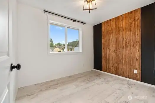 bedroom 1 with new lighting, black and wood accent wall and bonus this room also has a walk in closet  Could also be used as an office.  Great views out of window