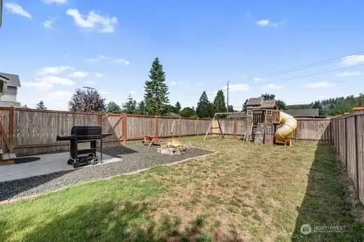 View from back side yard looking into the area off the slider.  Children play equipment will stay with home.  Graveled area off patio.