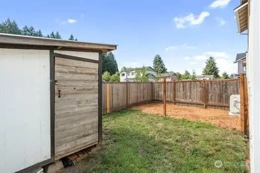 Small shed to stay with property and another view of heat pump and garden area