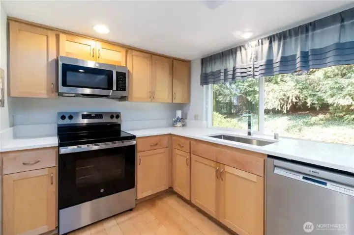 Inviting culinary space with a view of the lush outdoor greenery.