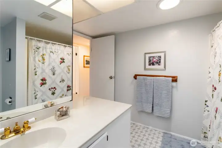 This bright and functional bath features a beautiful wrap-around mirror!