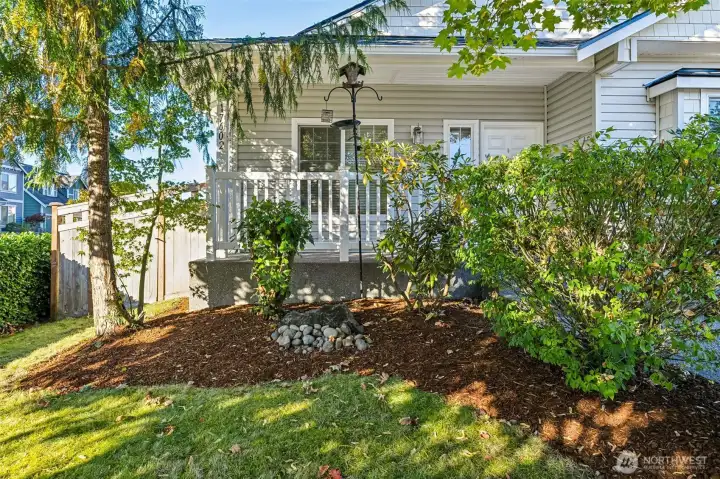 Sweet front porch with mature landscaping all around.
