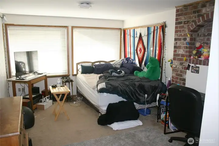 Room currently used as a bedroom with fireplace and access to upper level patio.