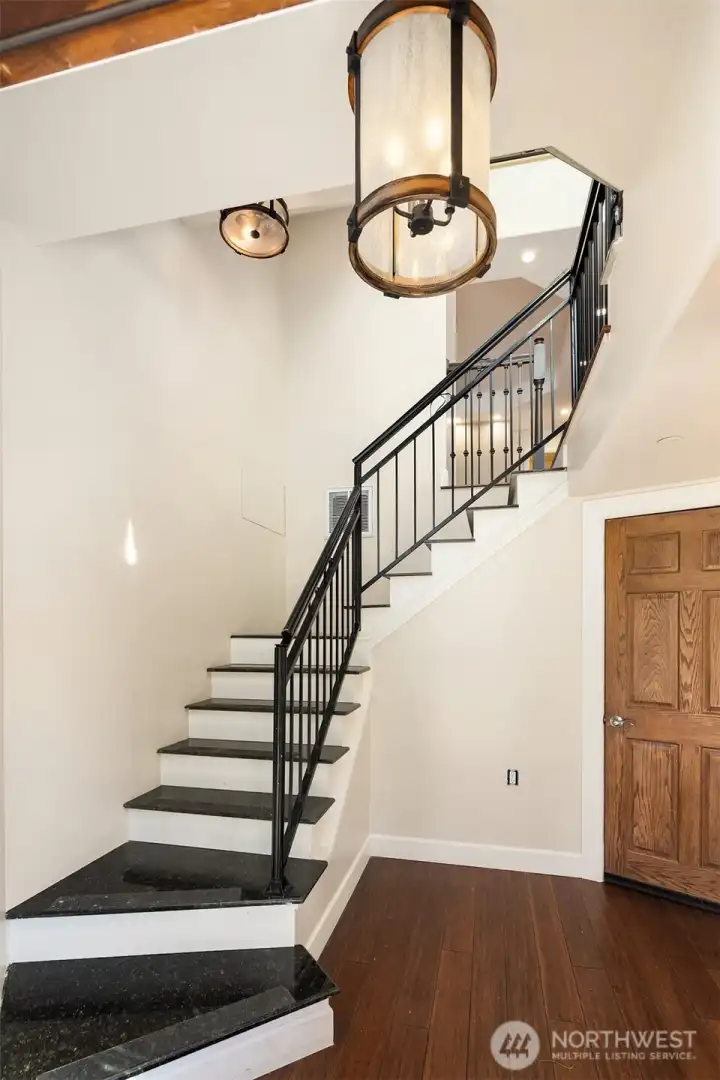 Curving stairwell up from the entry. Access to garage also from this entryway