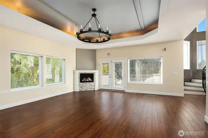Living room features electric fireplace and recessed ceiling with built-in lighting.