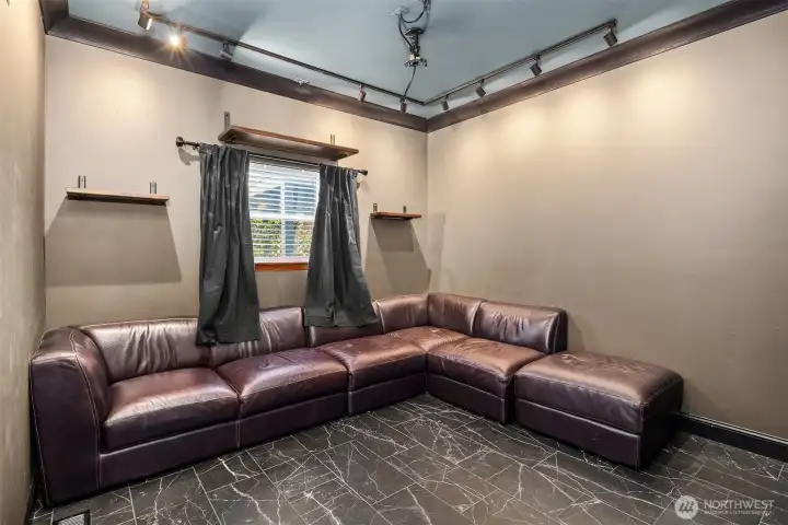 Media room with projector screen includes large, comfy sectional for enjoying the show.