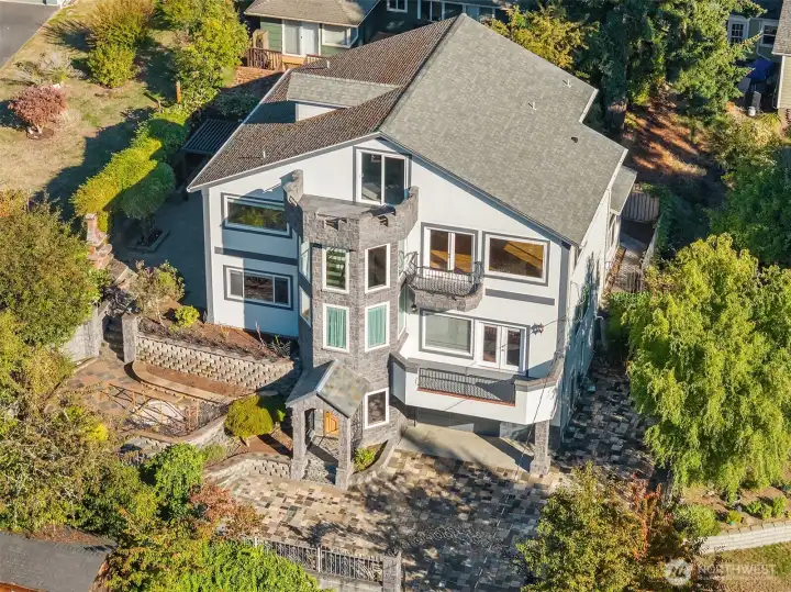 Home receives bright Western-facing light. Terraced gardens wrap around north side of home to entertaining patio in back. Granite stone tiles on driveway: functional and beautiful!