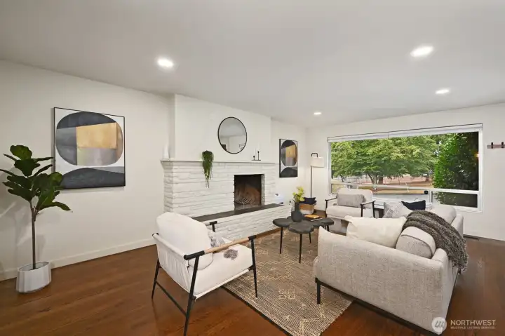 Open and spacious living room with wood burning fireplace and park view.