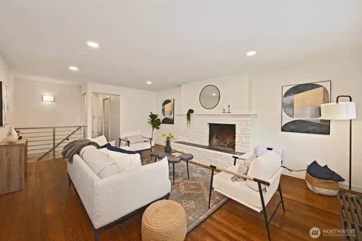 Open and spacious living room with wood burning fireplace and park view.