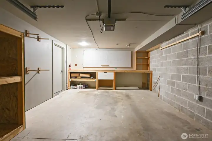 Spacious one car garage with storage space and work bench.
