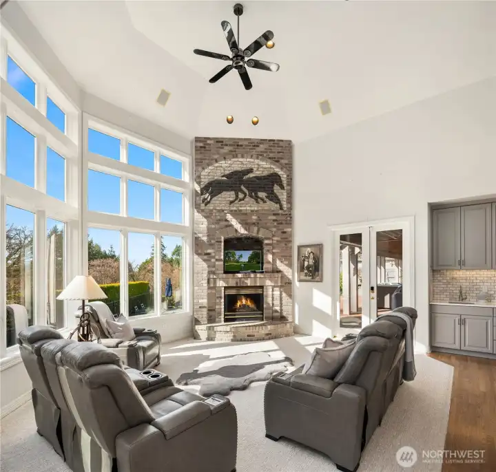 The grand family room showcases a curated, floor-to-ceiling statement fireplace.