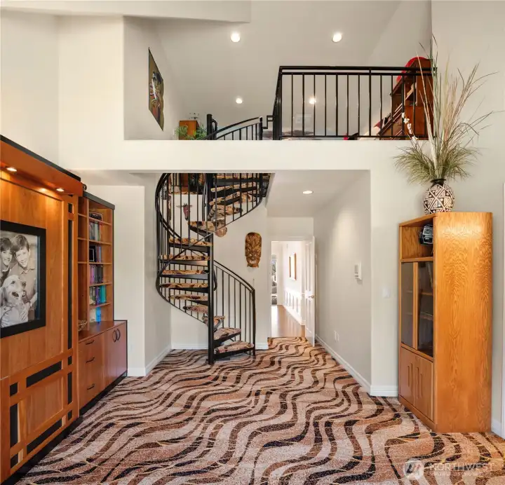 This versatile bedroom features custom shelving with a built-in Murphy bed and an elevated loft retreat.