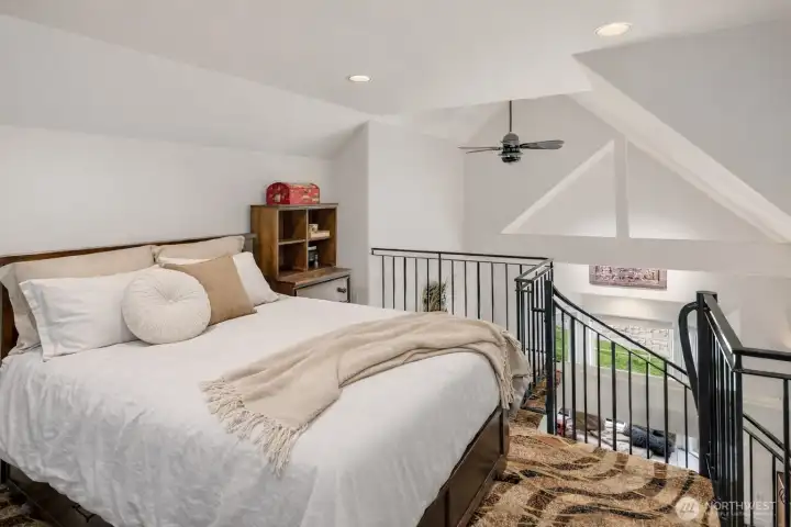 The bedroom showcases dramatic beamed, vaulted ceilings that elevate the space.