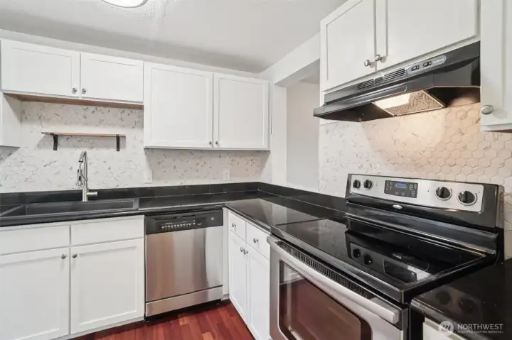Updated kitchen with granite countertops and modern hexagon tile backsplash