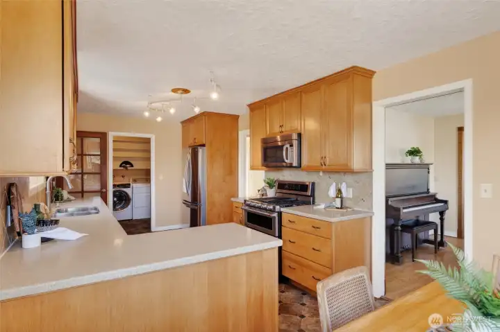 Kitchen with utility room in the background, breakfast nook in the foreground, and dining room to the right.