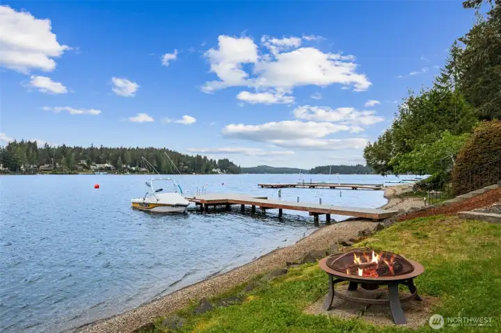 This is the payoff. Shared dock access puts Mason Lake directly into daily life, whether that means early morning paddleboarding, afternoon boat rides or kids cannonballing into the water until sunset. Buyers should verify future dock possibilities independently, but the current shared setup already makes getting out on the lake refreshingly easy. And then there is the fire pit area along the shoreline, which honestly feels essential for a property like this. Firelight reflecting on the water, marshmallows burning slightly too fast, people wrapped in hoodies staring at the stars pretending they are not staying another hour. This stretch of 60 feet of waterfront is not just beautiful, it creates an entire atmosphere around the home.