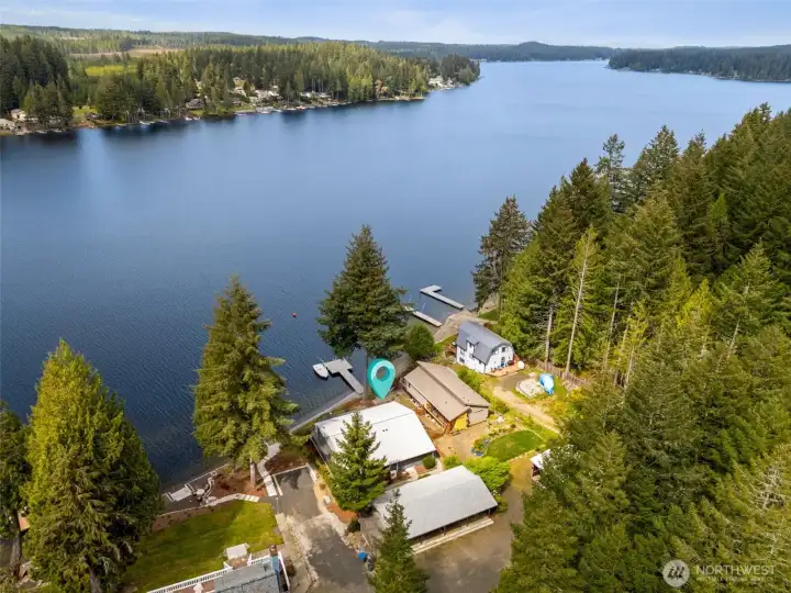 This aerial really puts the whole setting into perspective. From above, you can see the home’s position between the upper parking and carport area and the waterfront below, with the shared dock extending out into the lake and the boat mooring whips already installed on this property’s side. Such a great feature for keeping your boat positioned and protected at the dock without the constant hassle of repositioning lines every five minutes. And from this vantage point, you start to appreciate just how expansive Mason Lake truly is. As the second-largest freshwater lake in Mason County, it has a big-water presence that feels wonderfully open and scenic. Bald eagles and great blue herons are common sights here, soaring over a landscape where private waterfront homes blend with surrounding commercial timberlands, creating a backdrop that feels natural, peaceful and very Pacific Northwest.