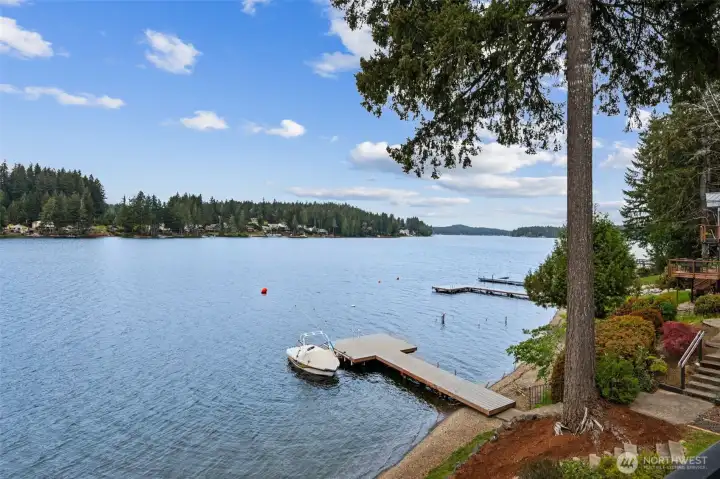 And this is why people fall in love with Mason Lake. Standing at the edge of the brand new deck, you get an uninterrupted view across sparkling water with the shared dock sitting just below, ready for everything from lazy swims to full-speed summer fun. Mason Lake stretches roughly 1,000 acres and nearly 4 miles long, with depths reaching up to 90 feet, giving it that big-open-water feel people crave without losing the welcoming community atmosphere. Jet skis, water skiing, paddleboarding, swimming, floating until sunset, this lake fully supports the fun side of waterfront living. And the fishing here is no joke either, with rainbow trout, bass, catfish and even salmon calling these waters home.