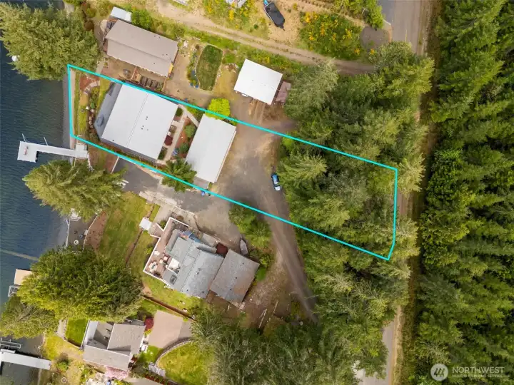 From above, you really start to appreciate how much this .34-acre lakefront lot offers. The property reaches from the shoreline all the way up to the street, with the shared driveway winding naturally down toward the four-car carport and main home. It creates a layered, tucked-into-the-land feeling that suits the lakefront setting beautifully. This view also helps show how accessible and usable the property layout is overall, with parking, entertaining areas and waterfront access all working together comfortably, and added bonus, the home already includes exterior cameras and a security system for extra peace of mind.