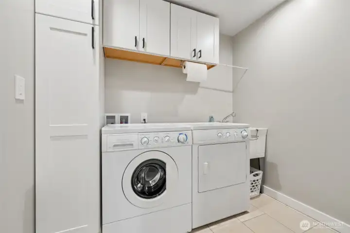 The included high-efficiency front-loading washer and dryer are already in place, while the utility sink instantly earns its keep after sandy feet, wet towels, swimsuits, paddleboard days and whatever else comes back from the water with you. Built-in cabinetry keeps supplies tucked away nicely, and that drying bar over the sink is one of those little details that becomes wildly useful once you actually live here. Bathing suits, towels, workout gear, all handled without draping things across every chair in the house. The durable tile flooring keeps cleanup easy too, which feels especially smart for a waterfront property where life occasionally arrives a little damp and messy.