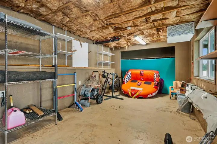 One of two lower-level storage spaces, this area opens the door to a surprising amount of future flexibility. Right now it is doing very responsible lake-house things like storing water toys, overflow supplies and the all-important extra fridge dedicated to cold drinks and snack survival during busy weekends. But the potential here goes much further. These lower-level rooms could absolutely evolve into additional finished living areas, bonus rooms, guest quarters, hobby spaces or more depending on what the next owner wants to create. And because both rooms have direct access out to the covered patio, they already feel more connected and usable than typical basement storage. Worth noting too, this home is equipped with two furnaces and was set up with duplex-style flexibility in mind, plus heat pump cooling for comfort upstairs.