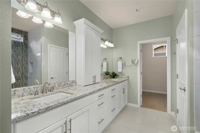 Primary bath offers Quartz counters with two undermount sinks, beautiful cabinetry and tile floors.