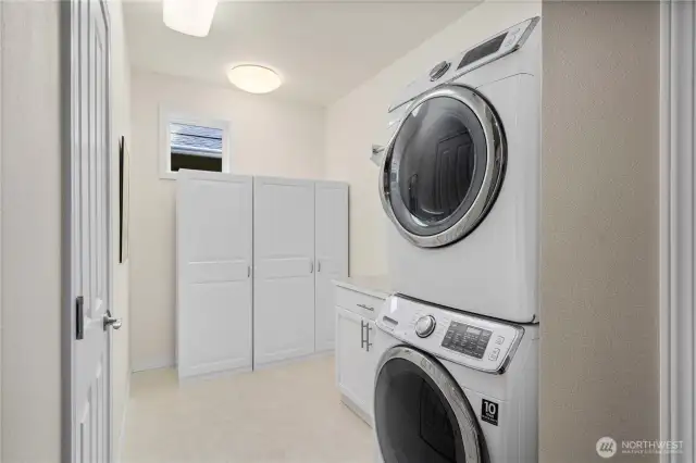 Laundry room offers extra space and a large closet. Appliances stay with home.