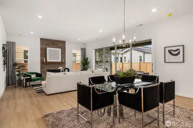 Open concept dining area and great room with multi stack slider panel doors open to covered patio.  Photos are for illustrative purposes only
