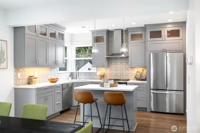 Sleek kitchen with breakfast island and stainless appliances.