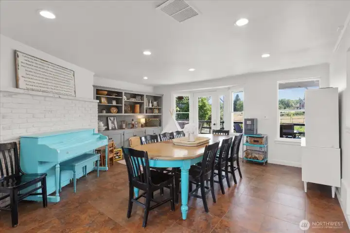 Extra-large dining room off kitchen with access to covered patio deck, built-ins and recessed lighting.