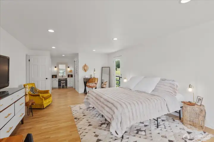 Private primary suite with hardwood floors,   recessed lighting, access to wrap around   deck, walk-in closet and newly renovated   ensuite bathroom.