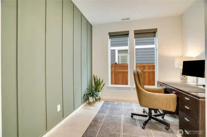 Elegant main-floor office with textured accent wall and crisp, curated details.