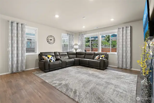 Discover the perfect blend of comfort and connectivity in this spacious living room, which opens gracefully to the dining area and kitchen. Large windows offer a serene view of the expansive backyard, seamlessly extending your living space outdoors.