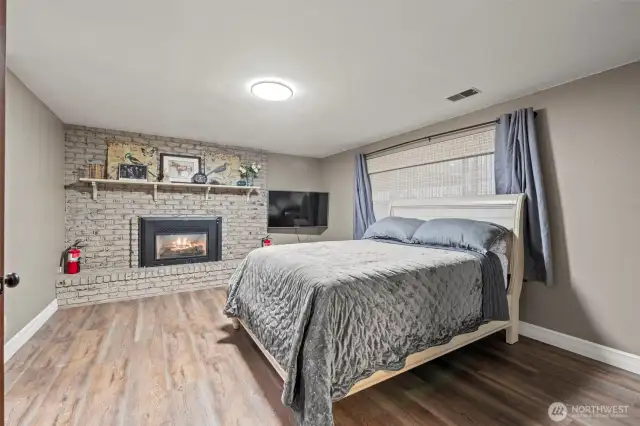 The lower level bedroom includes upgraded vinyl-plank flooring and its own fireplace.