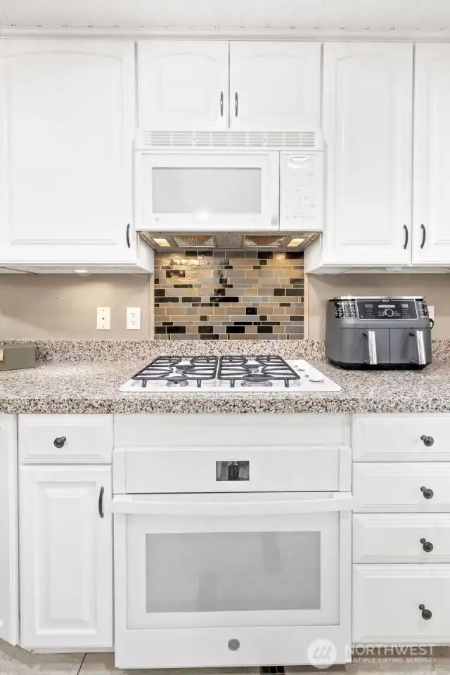 A gas cooktop and tile backsplash accent the kitchen quite nicely.