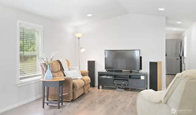 Spacious and bright, the vaulted ceilings extend through the great room. On the right, you can see the back door that leads to sunshine and fresh air.