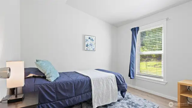 This second bedroom looks out onto the lush, private surroundings—offering a quiet retreat with a calming green view that makes the most of this peaceful setting.